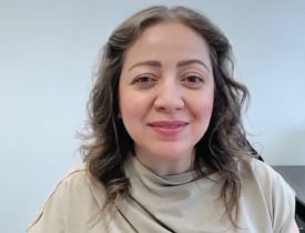 Noura Almasri in a cream top against a light office background.